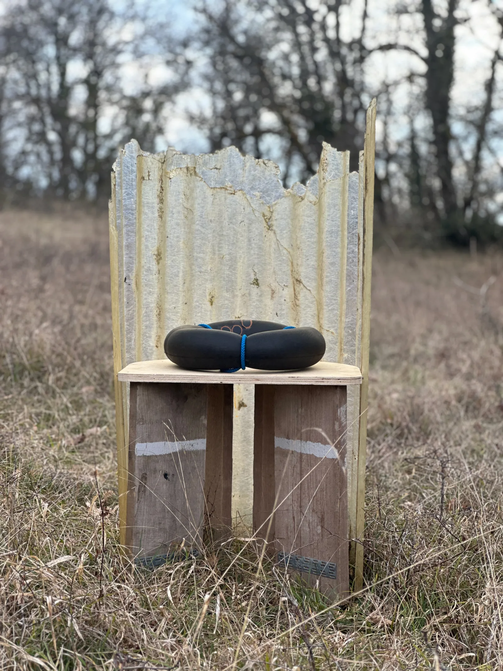 Zitobject in het veld: golfplaat, steigerhout, gevonden rubber.